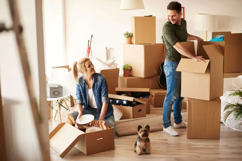 Couple packing moving boxes in a new home. 