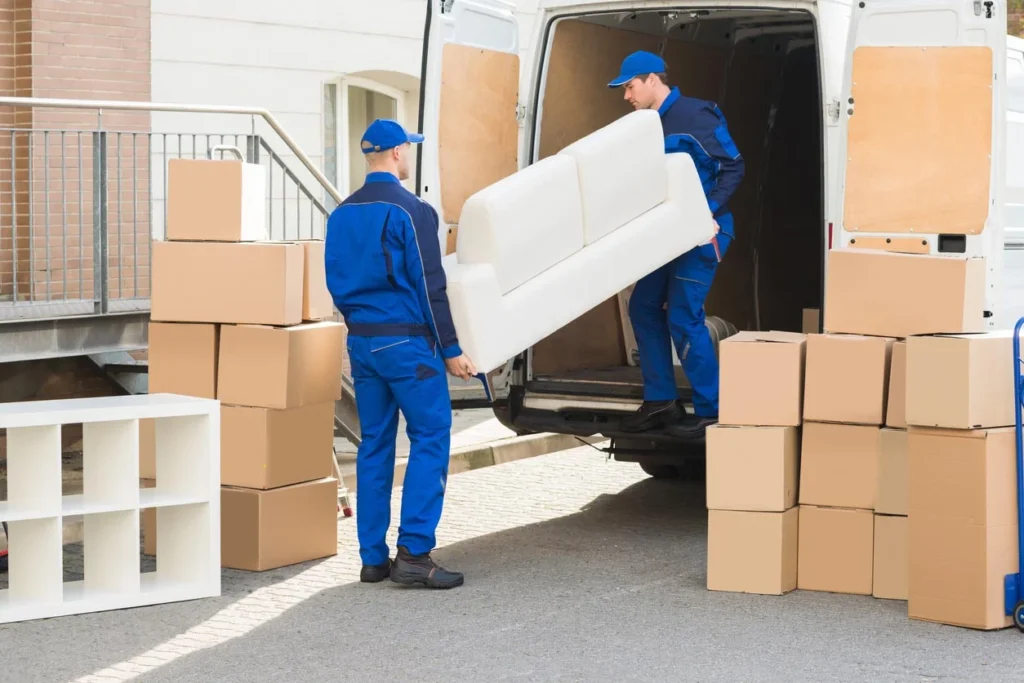 Movers loading furniture and boxes into a moving truck.